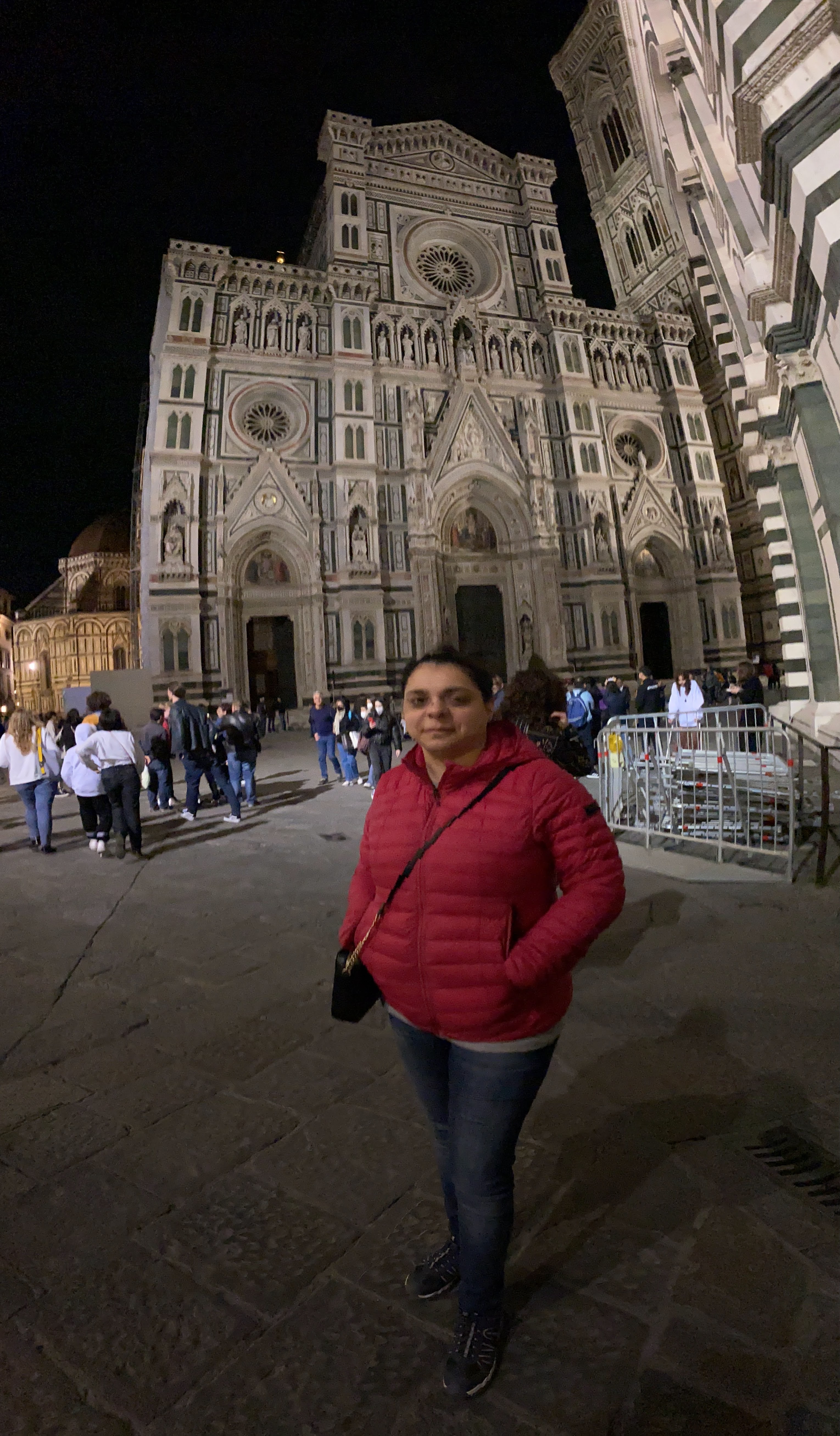 The magnificent Florence Duomo illuminated at night, bustling with evening crowds.