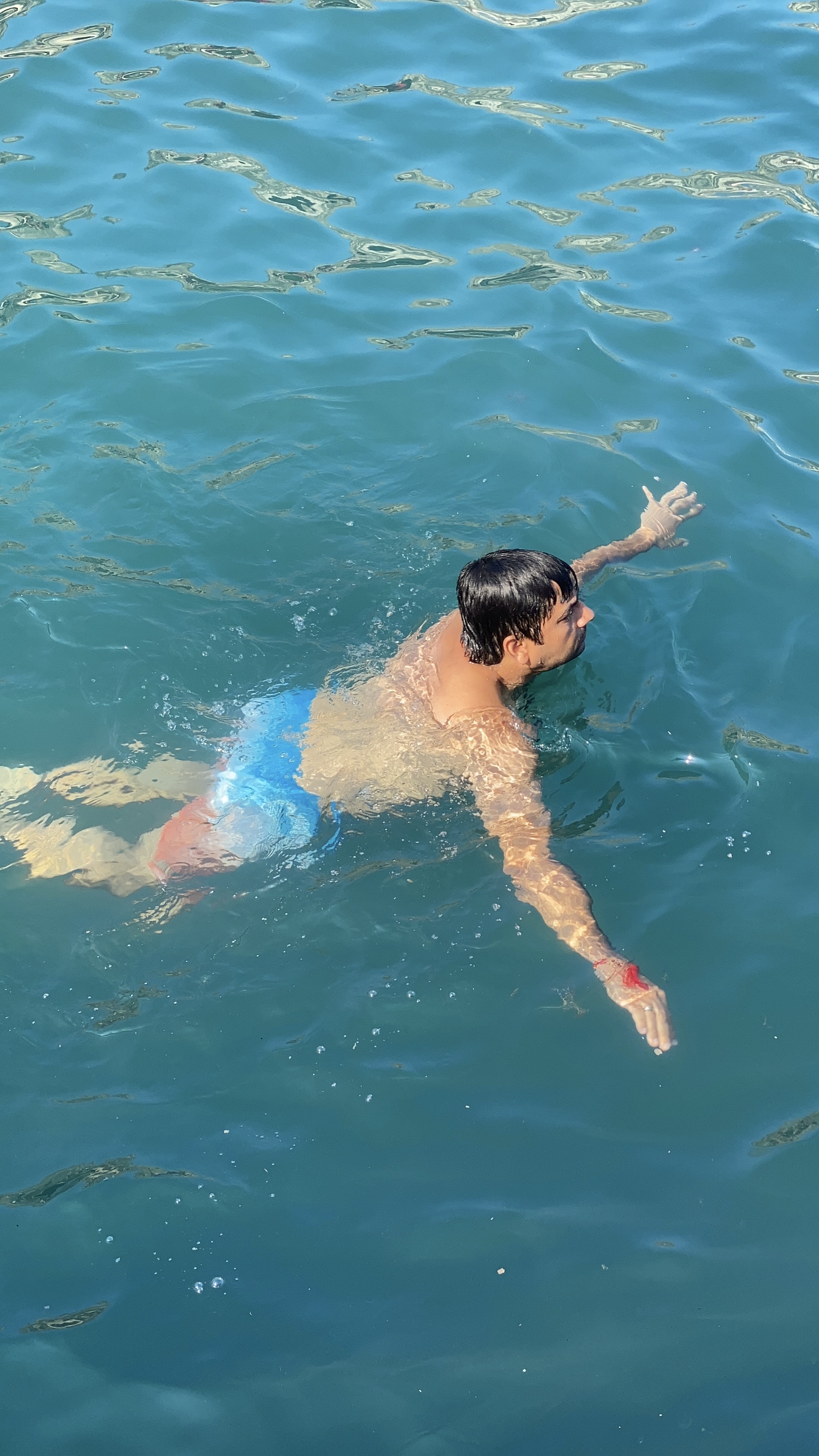 A person swimming in the clear, blue waters of the Mediterranean Sea.